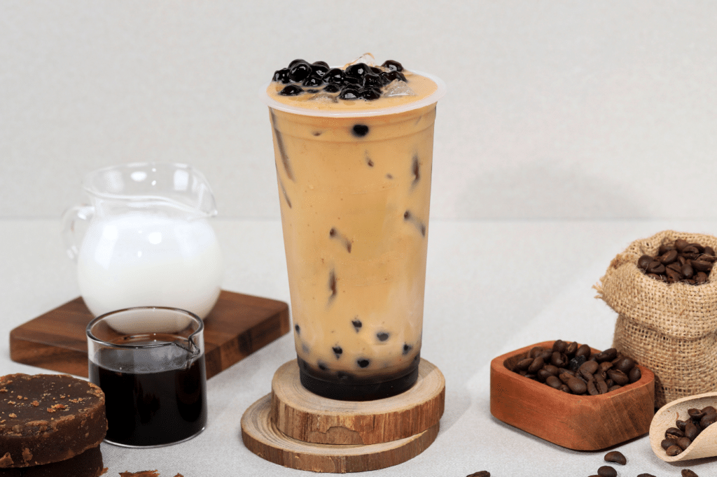 An Image of a Bubble Tea with Konjac Boba and Coffee Beans on the Side