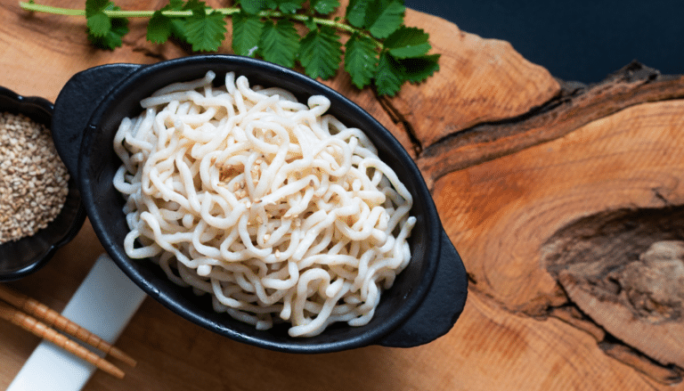 An image of a Healthy food concept organic Noodle or spaghetti Shirataki Konjac in black ceramic cup with copy space