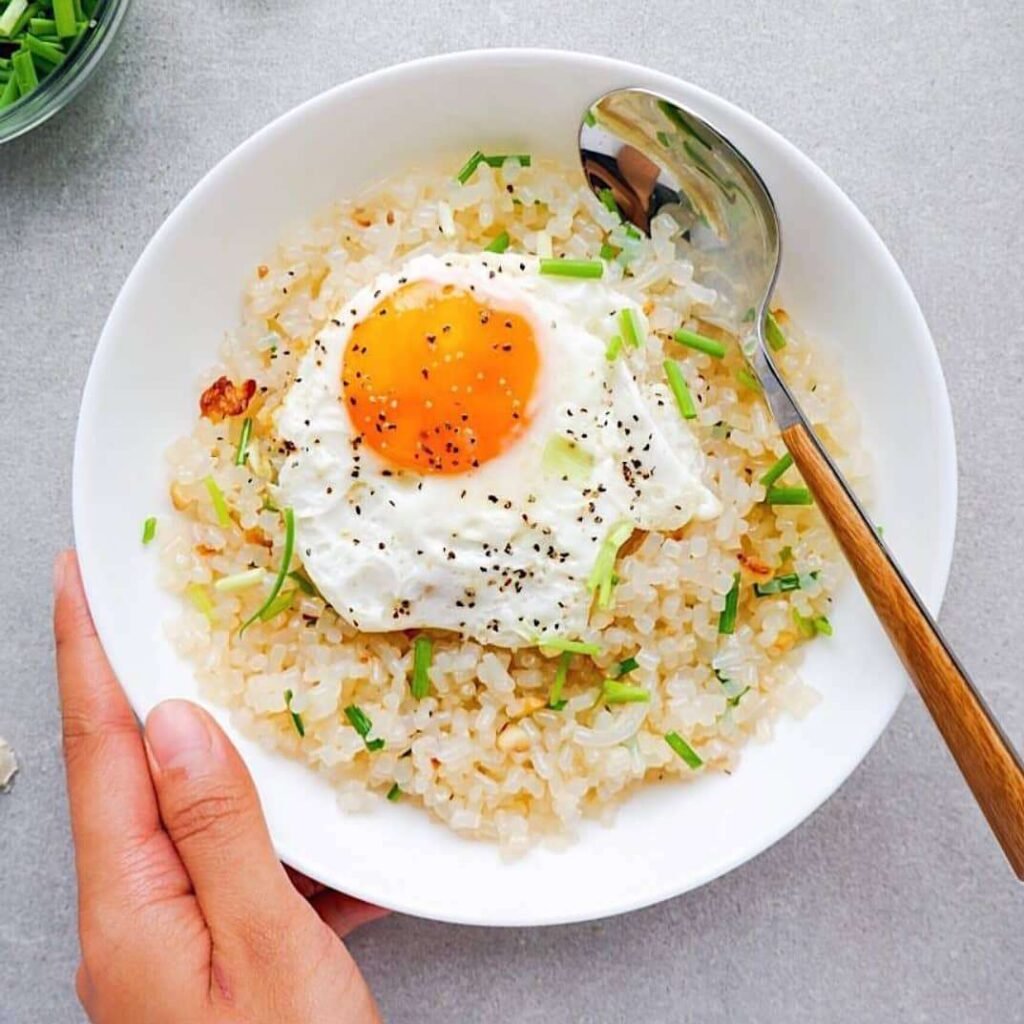 Low-carb konjac rice keto meal with sunny-side-up egg and chives.