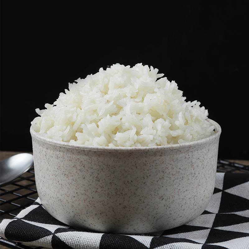 A bowl of cooked shirataki rice, served in a speckled bowl on a patterned cloth.