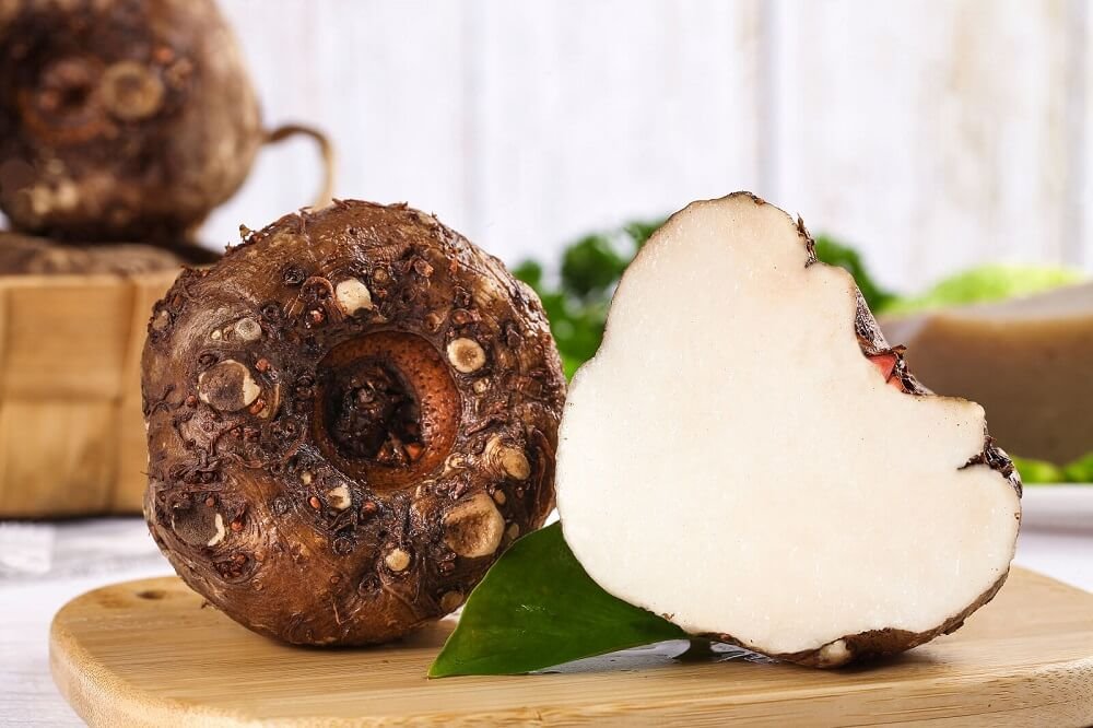 Close-up of konjac root, showcasing its brown, textured exterior and the starchy white interior, a key ingredient in low FODMAP cooking.