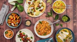 A colorful spread of delicious low FODMAP dinner ideas, featuring dishes like prawn spaghetti, vegetable tacos, tofu curry, and more.