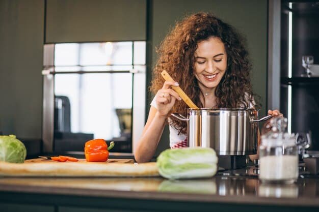 A smiling woman stirring a pot on stovetop in in the kitchen.